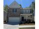 Charming two-story home featuring a brick facade, attached garage, and inviting front porch at 591 River Gardens Se Dr, Atlanta, GA 30354