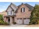 Brick two-story house with a three-car garage and landscaped yard at 2714 Vinings Oak Se Dr, Atlanta, GA 30339