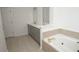 Main bathroom with double vanity, quartz countertop and a large soaking tub at 500 Chimney House Ct, Stone Mountain, GA 30087