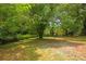 Large backyard with mature trees and a partially visible neighboring house at 819 Norwood Se Rd, Atlanta, GA 30315