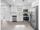 Modern kitchen features white cabinets, stainless steel appliances, and gray flooring at 819 Norwood Se Rd, Atlanta, GA 30315