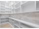 Bright walk-in pantry with white shelving and light beige tile backsplash at 2297 Lake Ridge Ter, Lawrenceville, GA 30043