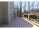 Wooden deck with black railing and view of trees at 399 Towler Dr, Loganville, GA 30052