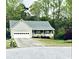 Gray house with a white garage door, front porch, and landscaped lawn at 399 Towler Dr, Loganville, GA 30052