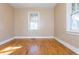 Well-lit bedroom featuring hardwood floors and two windows at 4471 Gibson Pl, Acworth, GA 30101