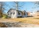 House exterior showcasing a gray siding, mature trees, and a long driveway at 4471 Gibson Pl, Acworth, GA 30101