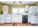 Galley kitchen with white cabinets, appliances, and wood floors at 4471 Gibson Pl, Acworth, GA 30101