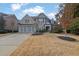 Brick two-story home with three-car garage and manicured lawn at 104 Johnston Farm Ln, Woodstock, GA 30188