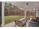 Relaxing backyard patio with woven furniture, overlooking a spacious lawn and wooded area at 6075 Marigold Way, Atlanta, GA 30349