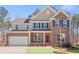 Brick two-story house with a white garage door and landscaped lawn at 6075 Marigold Way, Atlanta, GA 30349