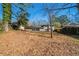 Spacious backyard with mature trees and a fenced area at 2725 Rainbow Forest Dr, Decatur, GA 30034