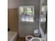 Bathroom with beige tile, toilet, and window at 678 Charlotte Nw Pl, Atlanta, GA 30318