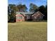 Charming single-story brick home with a well-maintained front lawn and mature trees at 143 Tracy Ln, Mcdonough, GA 30253