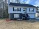 Two-story house with gray siding, stone accents, and a two-car garage at 6970 Old Bethsaida Way, Riverdale, GA 30296