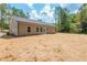 Home exterior featuring gray siding, back patio, and expansive backyard at 121 Hunters Ln, Powder Springs, GA 30127