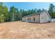 View of the back of the house with the freshly seeded backyard and wooded area at 121 Hunters Ln, Powder Springs, GA 30127