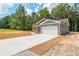 Long driveway leading to a gray siding home with a spacious two-car garage at 121 Hunters Ln, Powder Springs, GA 30127