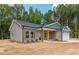 New construction home featuring gray siding, black roof, and a two-car garage with wood accents at 121 Hunters Ln, Powder Springs, GA 30127