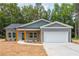 Charming new construction home with gray siding, wood accents, and a pristine two-car garage at 121 Hunters Ln, Powder Springs, GA 30127