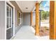 Close-up of a charming covered front porch with wood columns and black front door at 121 Hunters Ln, Powder Springs, GA 30127