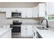 Elegant kitchen featuring granite countertops, stainless appliances and white cabinetry at 121 Hunters Ln, Powder Springs, GA 30127