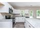 Modern kitchen featuring white cabinets, granite countertops, and stainless steel appliances at 121 Hunters Ln, Powder Springs, GA 30127