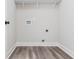 A practical laundry room with wood-look flooring and utility hookups at 121 Hunters Ln, Powder Springs, GA 30127