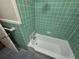 Green tiled bathroom with a white bathtub at 2842 Delowe Dr, Atlanta, GA 30344