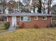 Brick ranch home with a metal roof, steps, and a yard at 2842 Delowe Dr, Atlanta, GA 30344