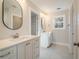 Double vanity bathroom with white cabinets and oval mirrors at 56 Veranda Walk, Dallas, GA 30157