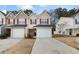 Tan siding townhouse with red shutters, two-car garage, and landscaping at 6977 Gallant Se Cir # 8, Mableton, GA 30126