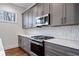 Modern kitchen features gray cabinets, white quartz countertops, and stainless steel appliances at 1453 Bridges Sw Ave, Atlanta, GA 30310