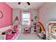 bedroom with pink walls, playful decor, and a rainbow accent wall at 3950 Oxford Park Ln, Cumming, GA 30040