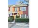 Brick two-story townhome with gray door, shutters, and manicured landscaping at 2884 Norfair Loop, Lithonia, GA 30038