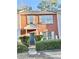Brick two-story townhome with blue door, shutters, and manicured landscaping at 2884 Norfair Loop, Lithonia, GA 30038