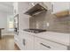 Modern kitchen features white cabinets, stainless steel appliances, and gray backsplash at 630 Darlington Commons Ne Ct, Atlanta, GA 30305