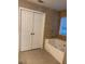 The primary bathroom features a standalone tub and custom tiled wall at 665 Roxford Ln, Buford, GA 30518