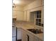 This kitchen features white cabinets, and a view out of the window over the sink at 345 Lexington Dr, Lawrenceville, GA 30046