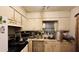 Vintage kitchen with white cabinetry, appliances, and a small window over the sink at 345 Lexington Dr, Lawrenceville, GA 30046