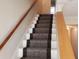 Carpeted staircase with wooden handrails leads to the upper level of this home at 345 Lexington Dr, Lawrenceville, GA 30046