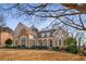 Two-story house with stone and brick facade, situated on a sloping lot with mature trees at 2760 Veltre Sw Ter, Atlanta, GA 30311