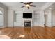 Open Gathering room with hardwood floors, fireplace, built-in shelving, and a ceiling fan at 2760 Veltre Sw Ter, Atlanta, GA 30311