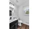 Simple bathroom with dark vanity, white toilet, and wood-look floor at 3569 Lynne Rd, Powder Springs, GA 30127