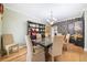 Elegant dining room with a glass-top table, chandelier, and a decorative bookcase and wall decorations at 10 Moss Landing Se Rd, Acworth, GA 30102