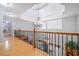 Elegant hallway with hardwood floors, decorative railing, and a chandelier, showcasing the home's sophisticated design at 10 Moss Landing Se Rd, Acworth, GA 30102