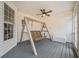 Cozy covered porch featuring a wooden swing, ceiling fan, and storage chest at 10 Moss Landing Se Rd, Acworth, GA 30102