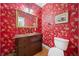 Unique powder room with bold wallpaper, decorative mirror, and elegant vanity at 10 Moss Landing Se Rd, Acworth, GA 30102