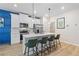 Modern kitchen with white cabinets, blue accent wall, and island with seating at 8194 Tiger Way, Riverdale, GA 30274