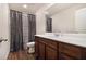 Clean bathroom with dark wood vanity, white sink, and gray shower curtain at 412 Vermeer Ct, Locust Grove, GA 30248