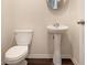 Small bathroom with pedestal sink and dark hardwood floors at 412 Vermeer Ct, Locust Grove, GA 30248